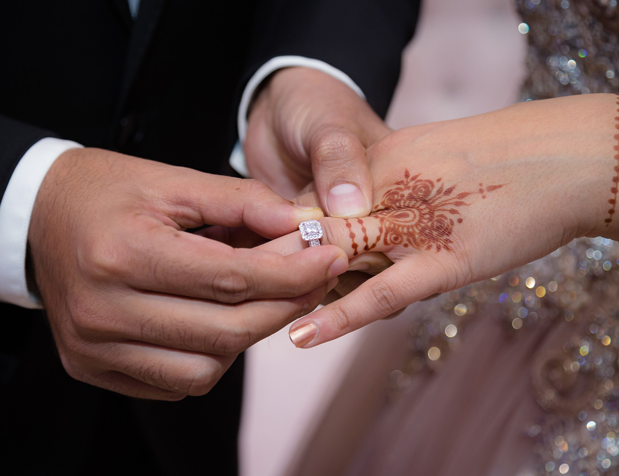 A groom inserts beautifull ring on brides finger on their engagement ceremony